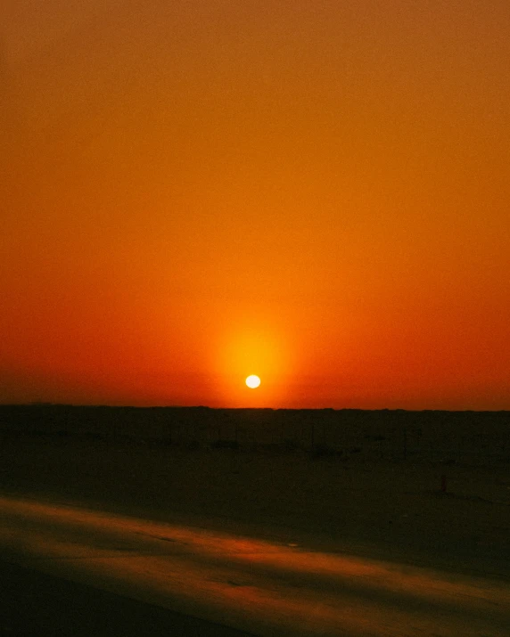 a sunset on the horizon of the desert