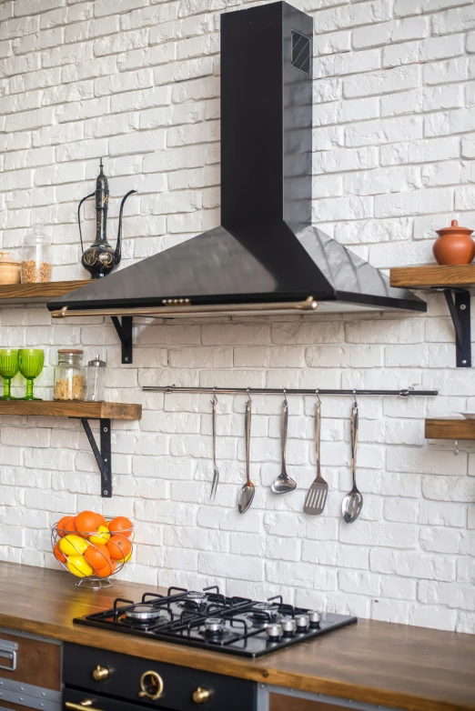 a kitchen with stove, hood and cabinets