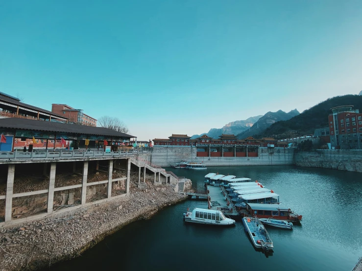 boats are lined up in the river under a bridge