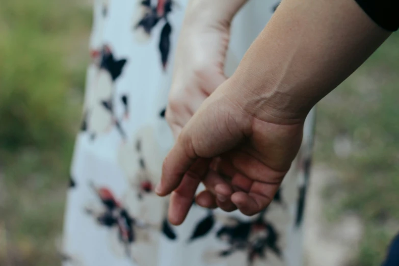 a close up of two people holding hands