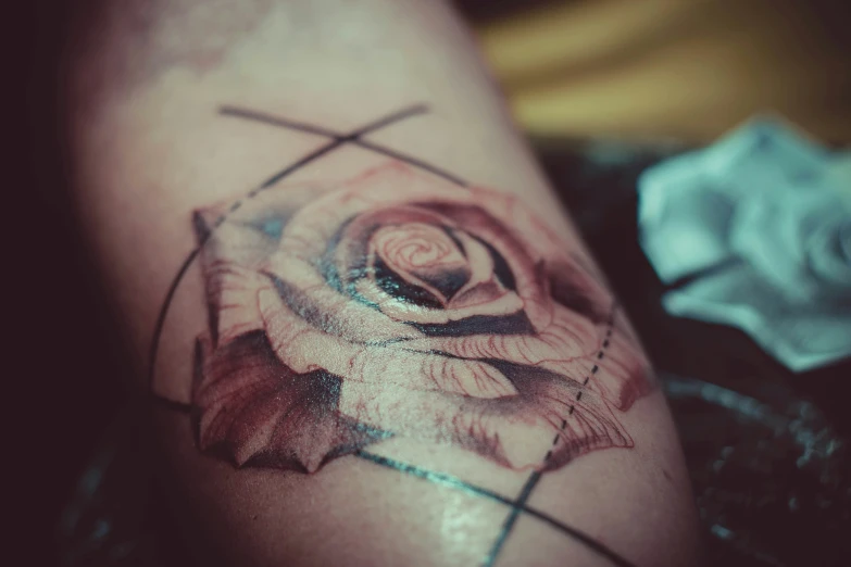 a tattoo depicting a flower in a circle on the thigh