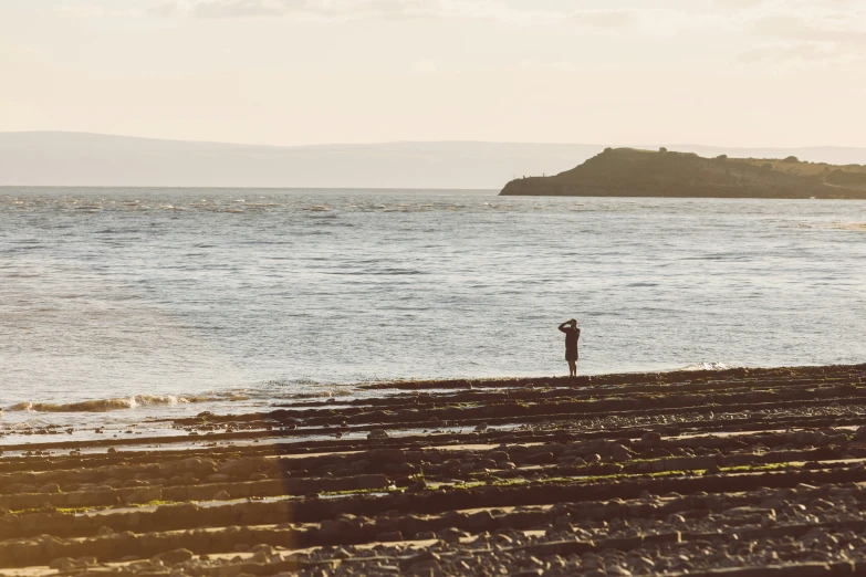 a man standing next to an ocean by the water