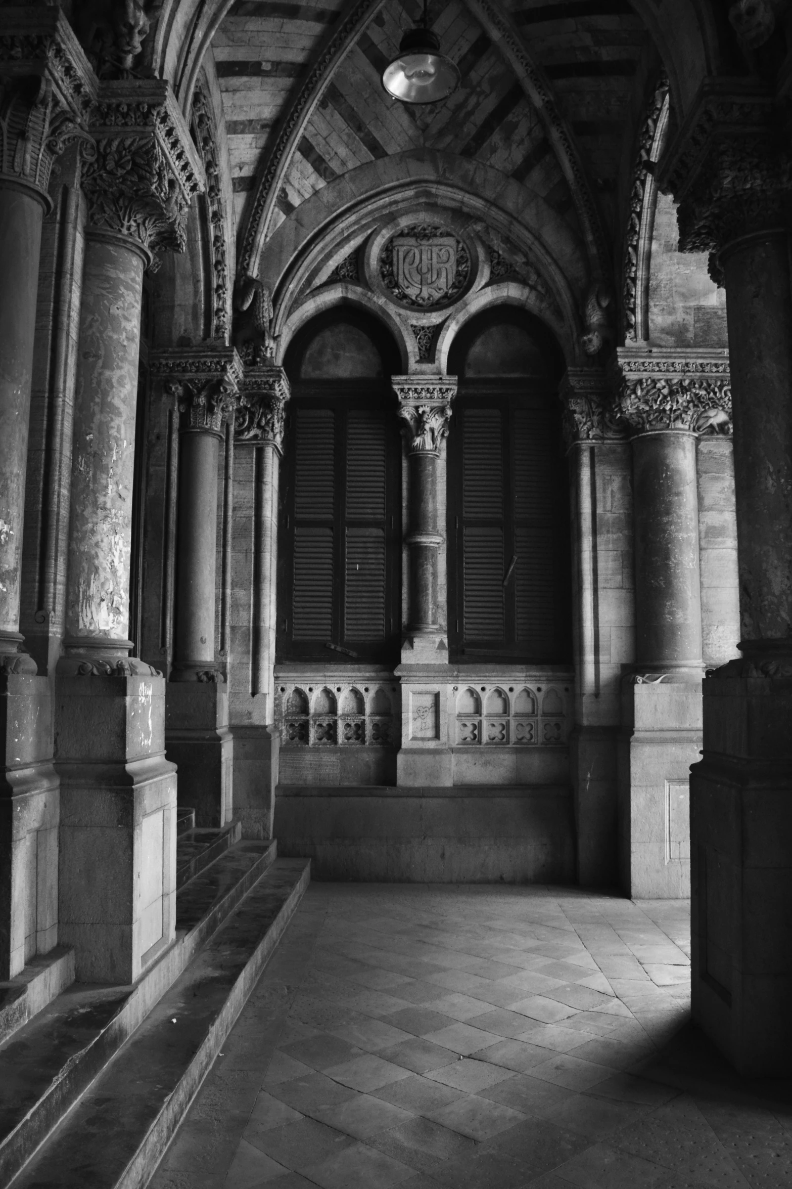 black and white po of empty foyer with stone stairs