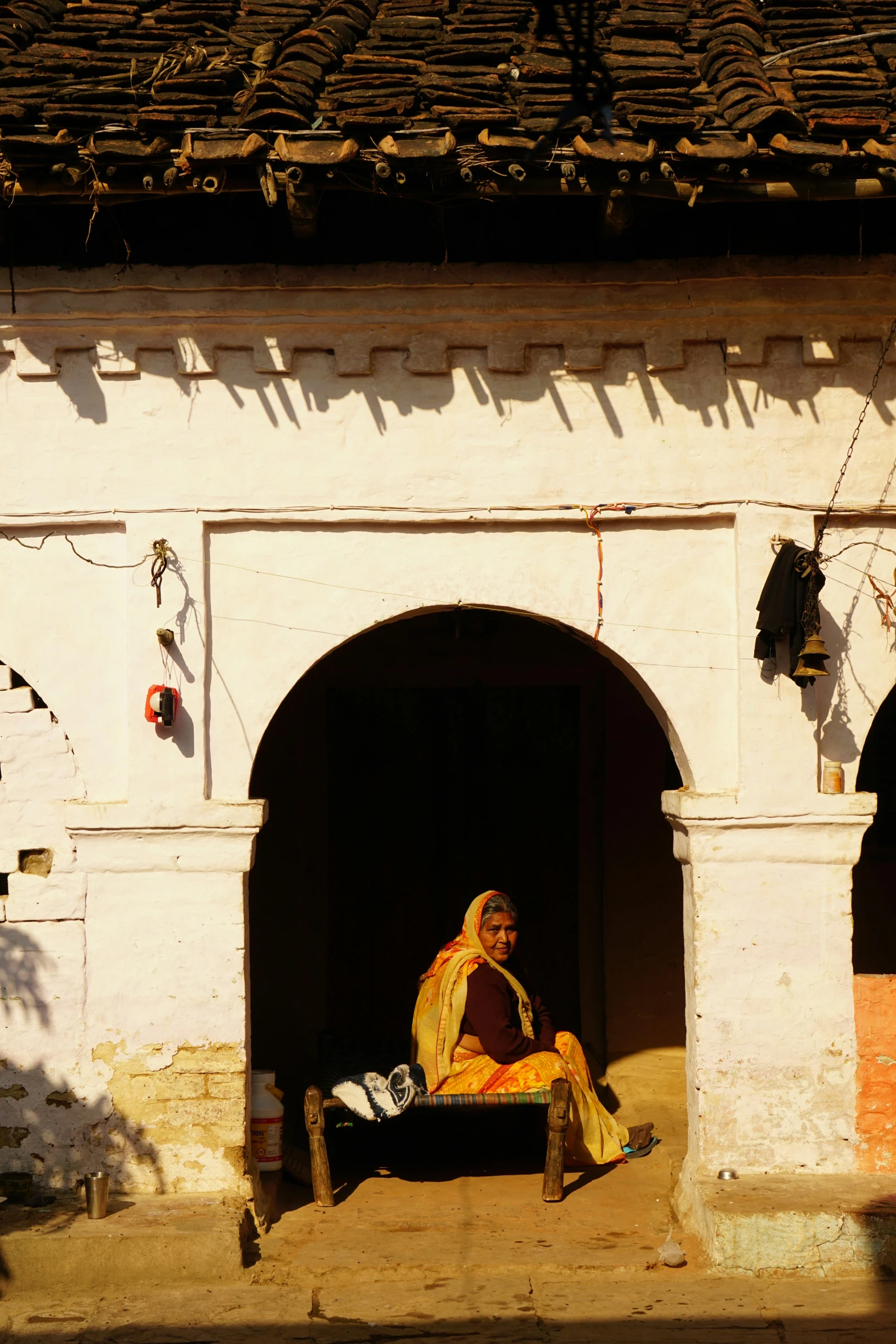 a woman in traditional garb sits in a doorway in a building