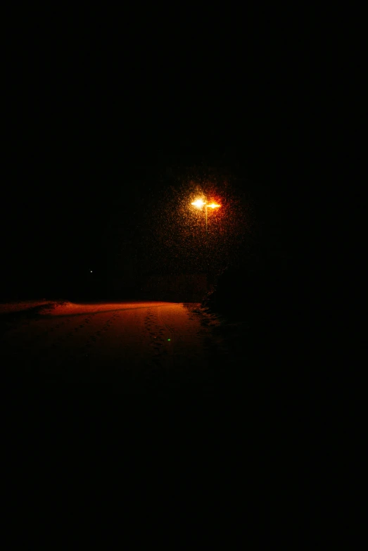 street light at night shining on a dirt road