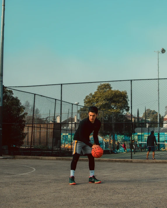 a person standing on a basketball court holding a ball