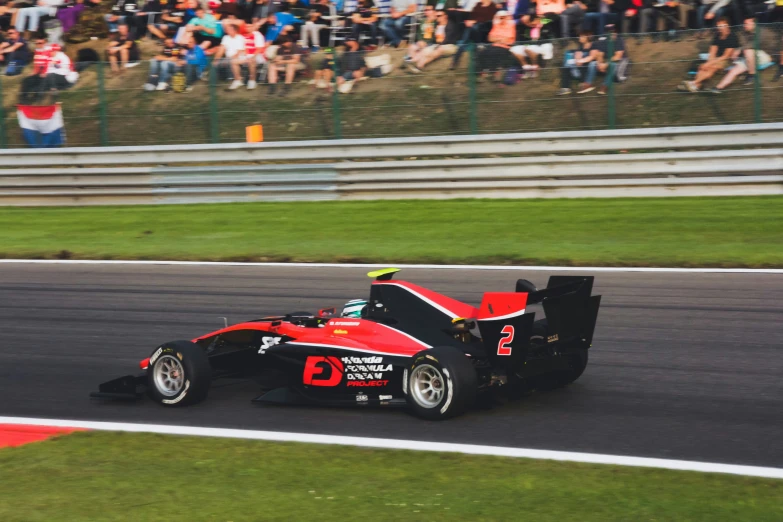 a red racing car rounding a corner on a race track