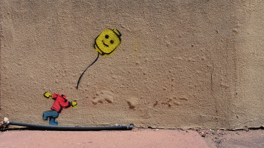 a boy in a red sweater with a yellow smiley face balloon