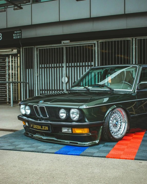 the green bmw is parked on the street