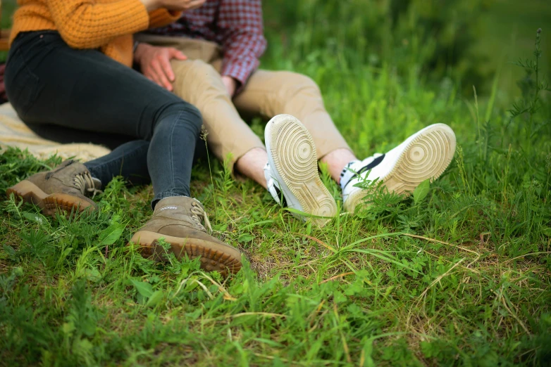 two people who are sitting down in the grass