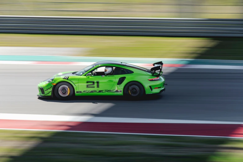 a racing car with a green paint job driving on the track