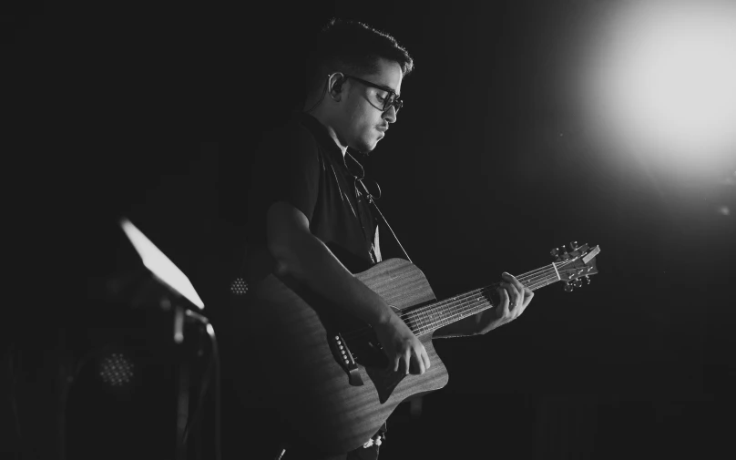 a man holding a guitar is staring ahead