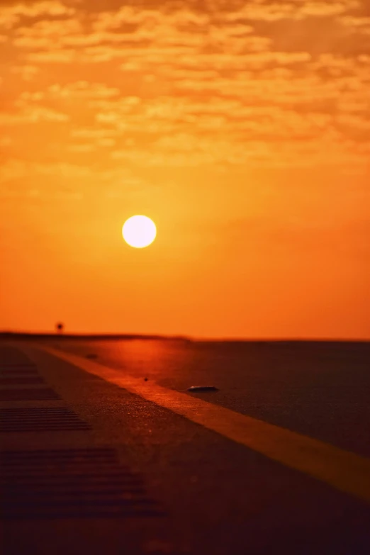 the sun is setting on an airplane runway