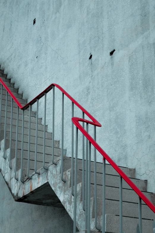 a stair case is painted red along with two black birds