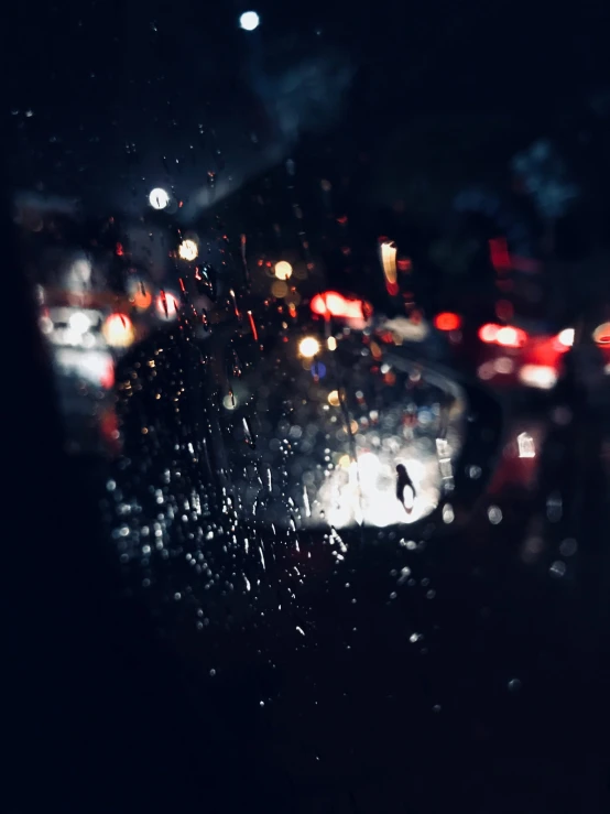 a man is walking in the rain in a car