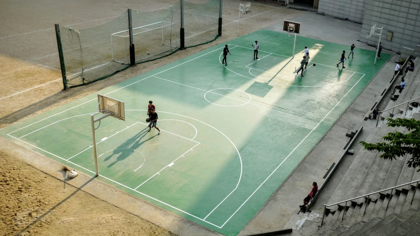 a group of people playing basketball in a sports field