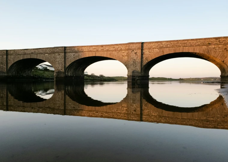 two stone arches with reflections on water