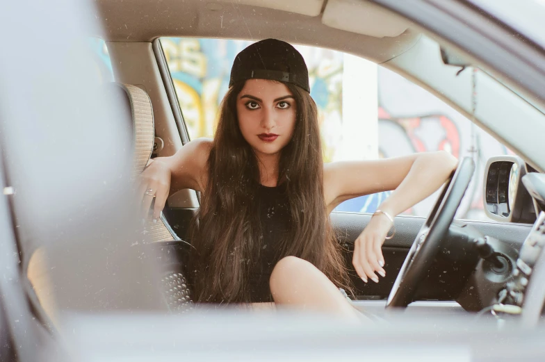 woman sitting in the passenger seat of a car wearing hat