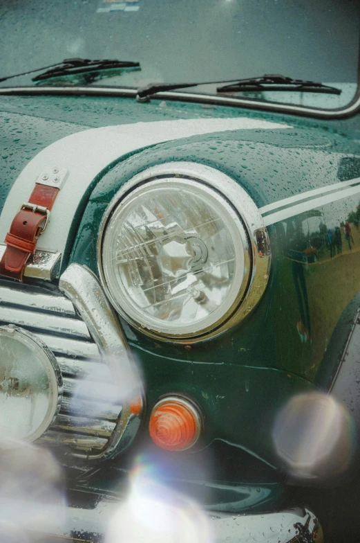 the front of a parked green car that is covered in ice