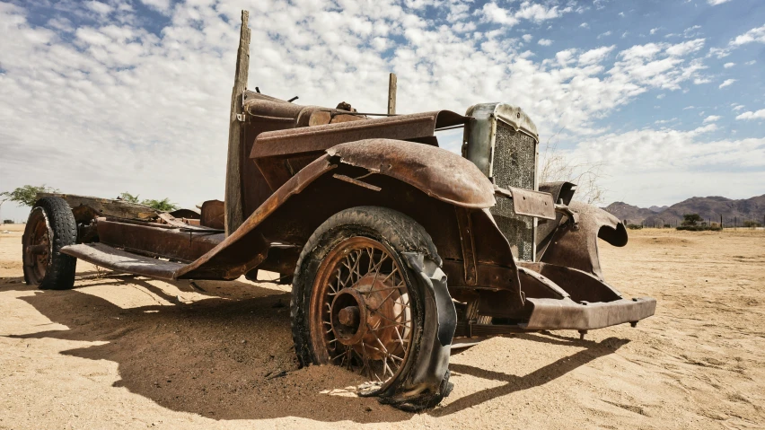 an old rusty car in the middle of nowhere