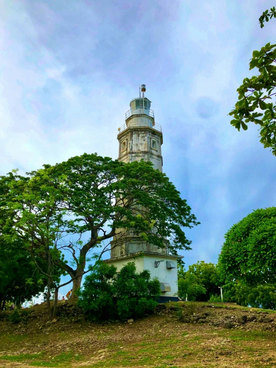 a white tower is shown on top of a hill