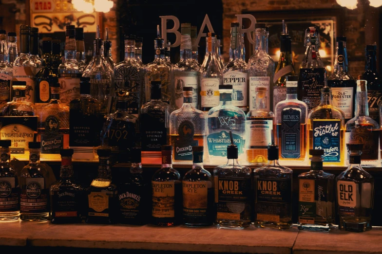 an assortment of liquor bottles with glasses on display