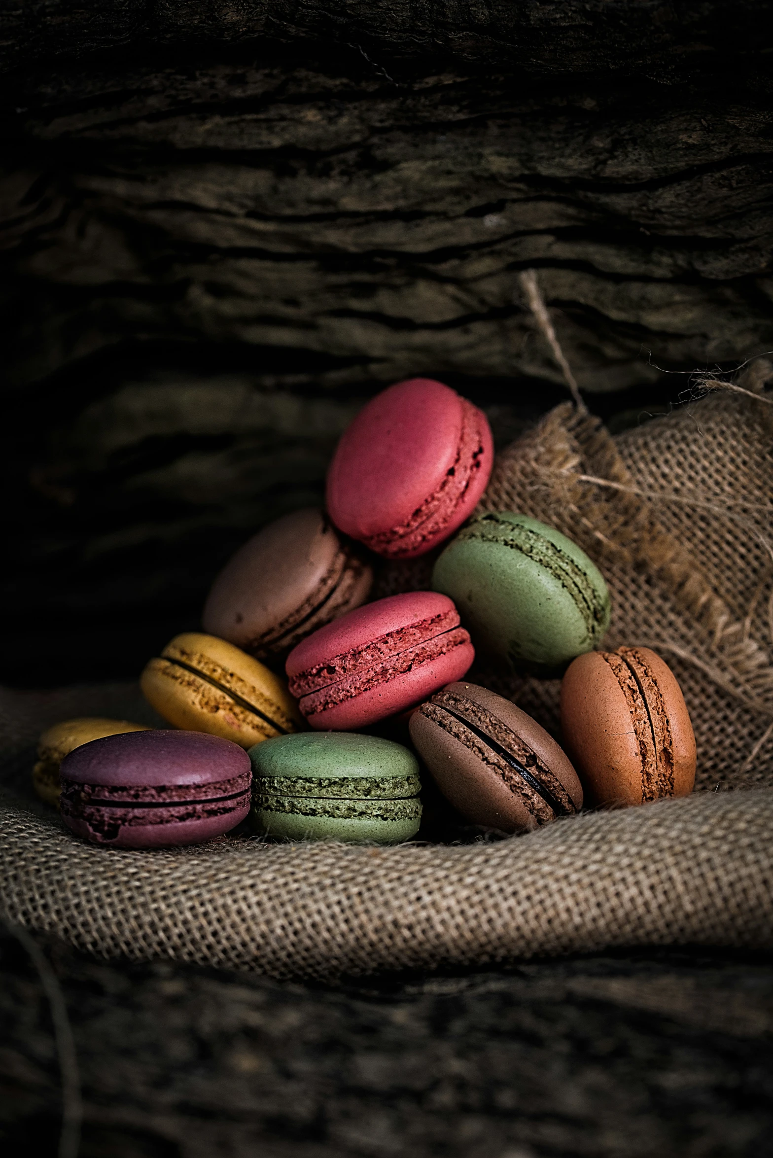 colorful macaroons sit together on a burlop of burlop