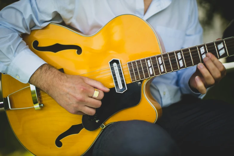 the man is holding an electric guitar outside