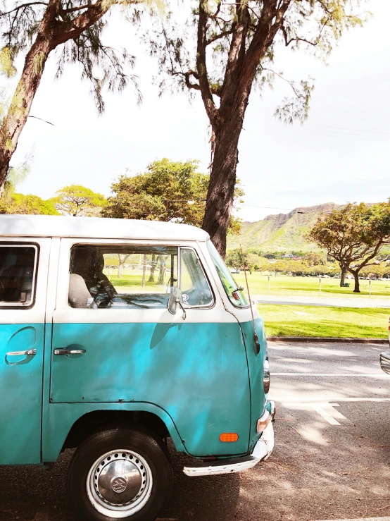 an old - style van sits parked in the parking lot