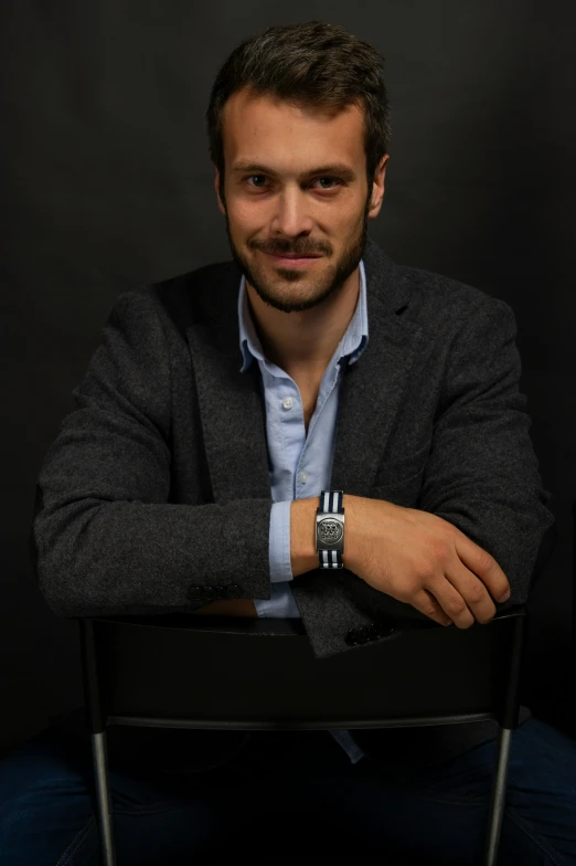 a man wearing a black watch sitting down