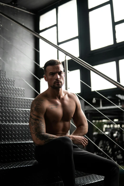 a man sitting on some stairs with his arms crossed