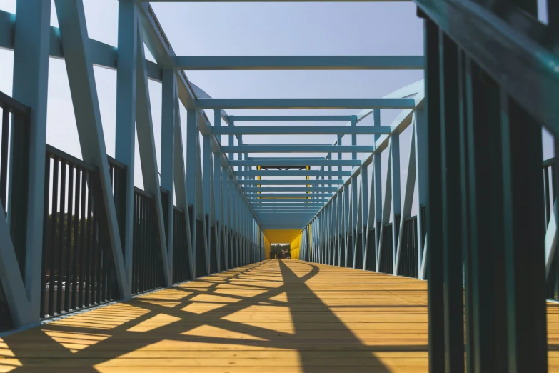 a wooden walkway with iron bars and shadows