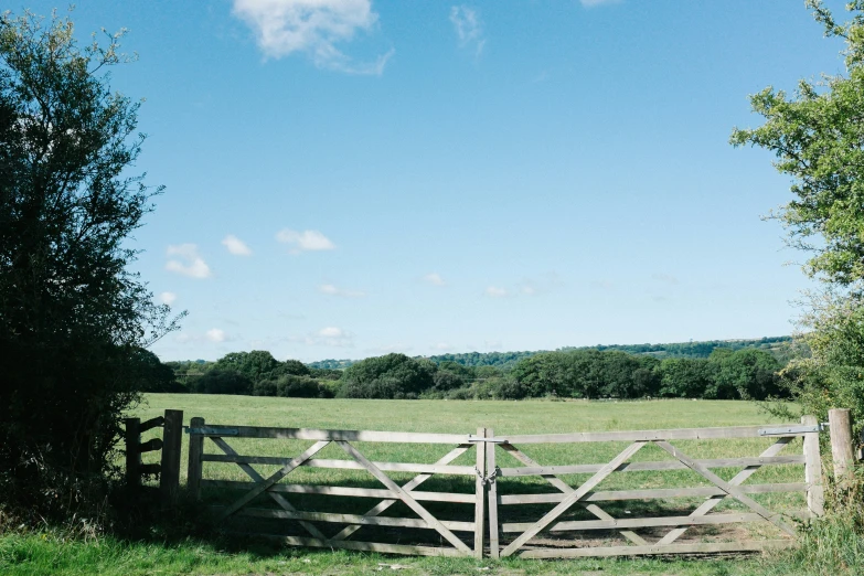 a large gate in front of a grass covered field