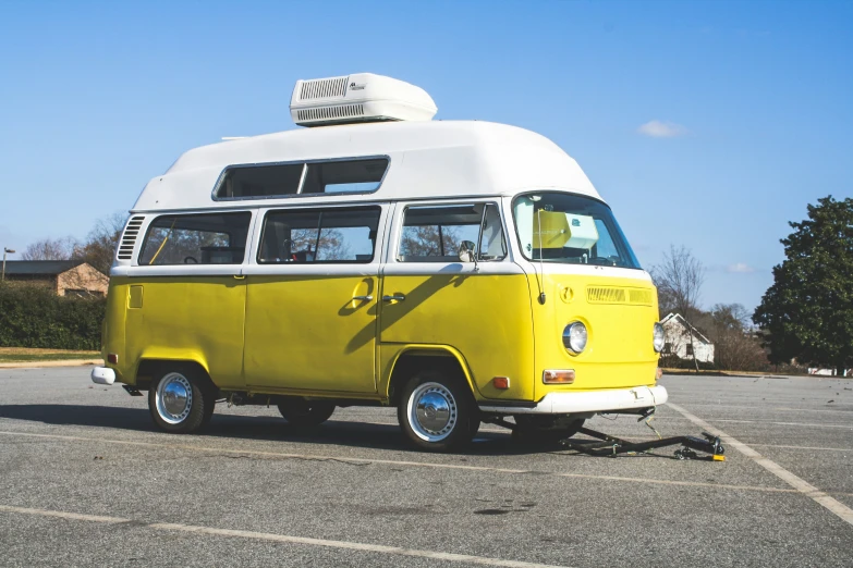 an old yellow and white bus is parked in a parking lot