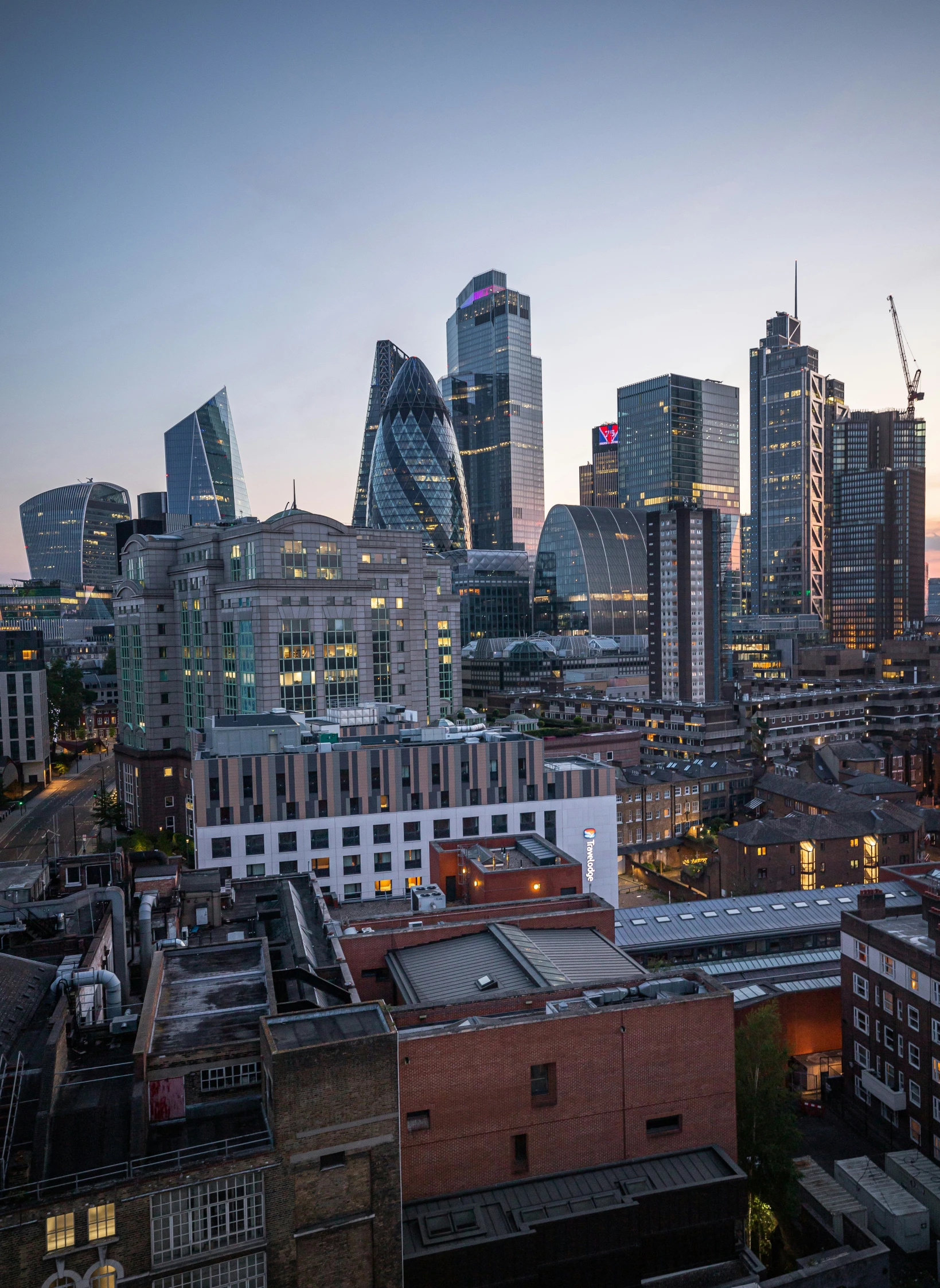 city skyline with buildings lit up at dusk