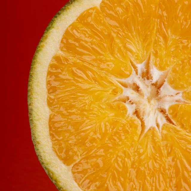 a half of an orange cut in half on a red background