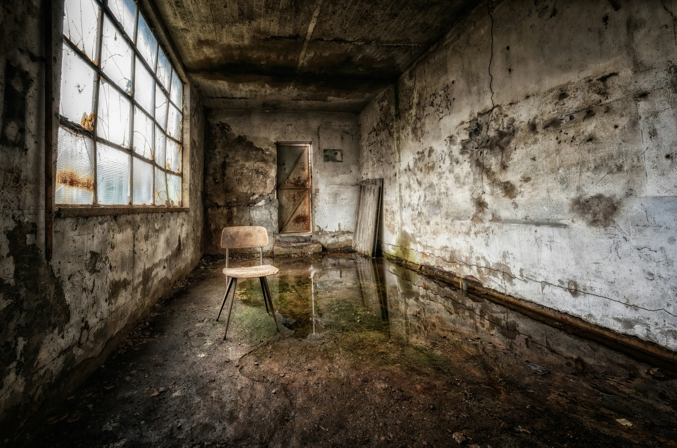 an abandoned room with a chair and two windows