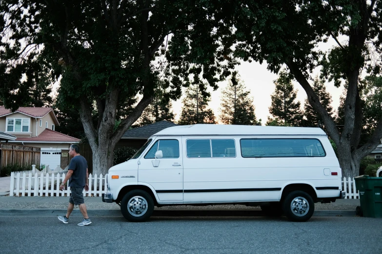 a white van is parked on the side of the road