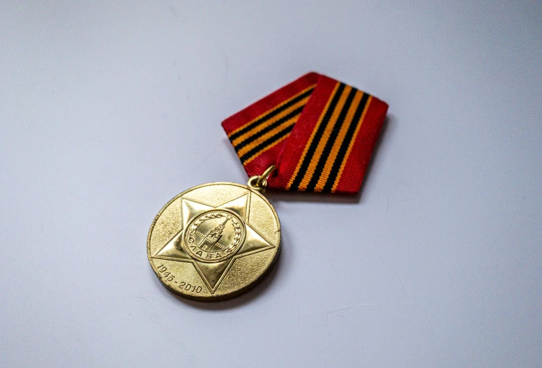 an old gold medal and a red striped tie