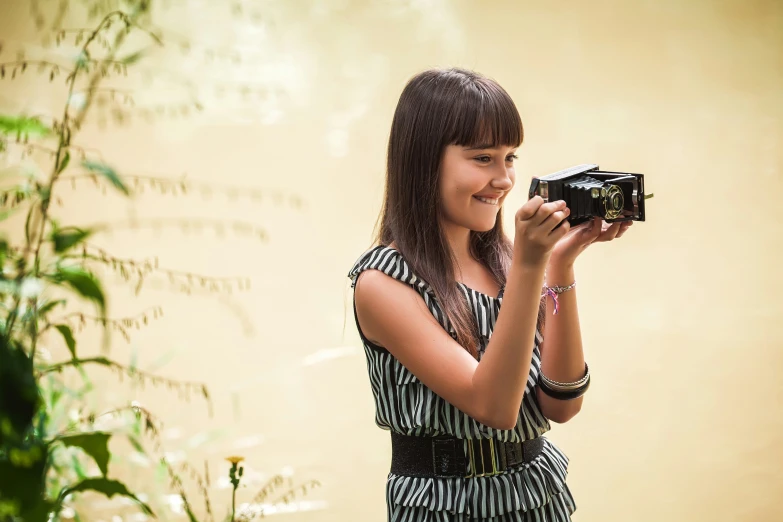  pographing herself with camera in studio