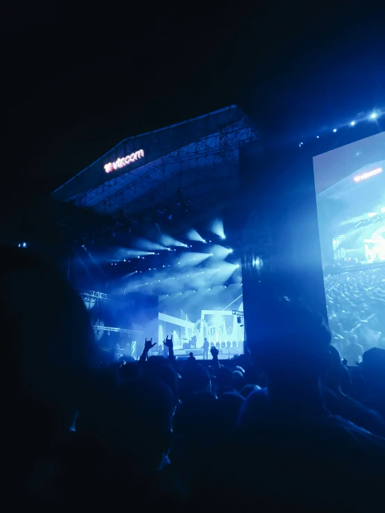 people are watching an event on large screens