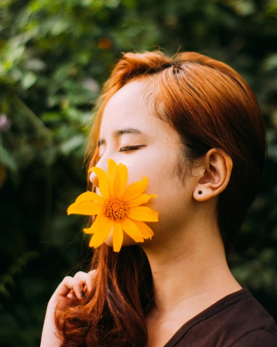 there is a woman with red hair and a flower in her mouth