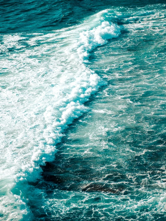 close up of waves in water crashing onto the shore