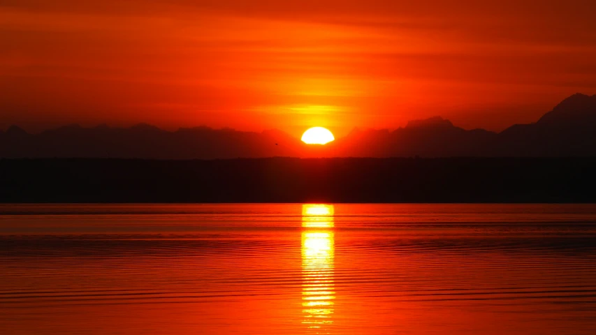 the sun is setting over a large body of water