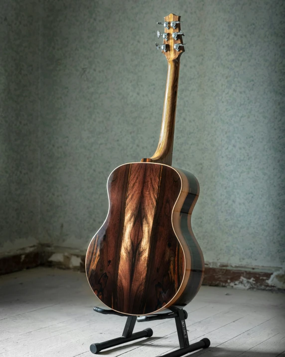 an acoustic guitar with the back on a stand in the corner of a room