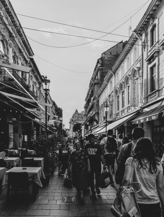 people walking down the street with many shops