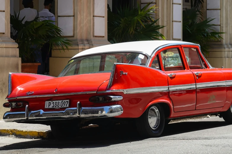 a red car sitting in front of a building