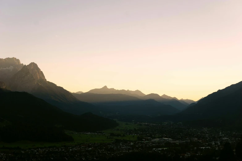 a scenic view of a valley and mountains during sunset