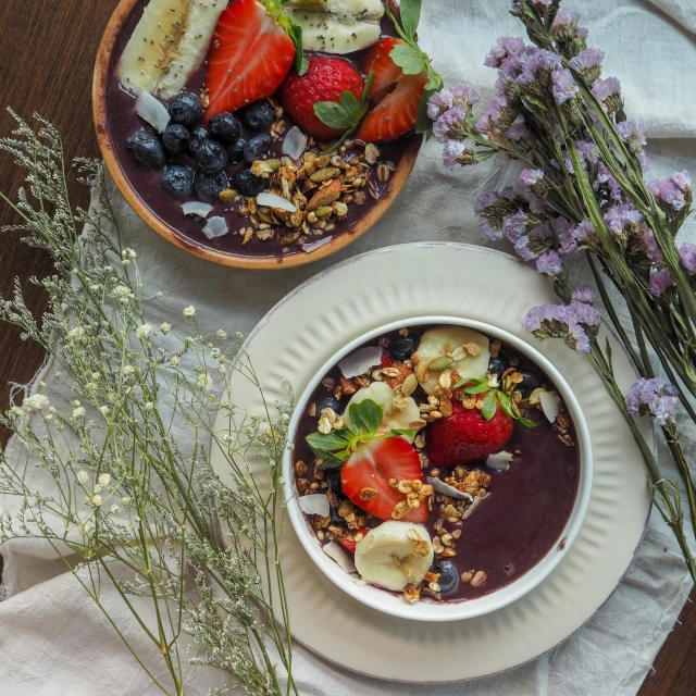 a bowl of fruit and yogurt on two plates