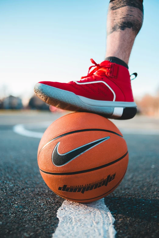 a person stands on top of a basketball ball